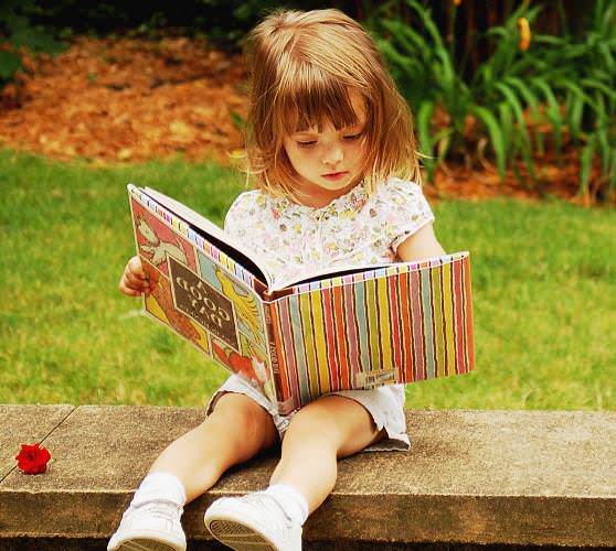 Ребенок увлеченно читает книгу