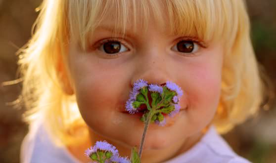 Девочка нюхает цветок