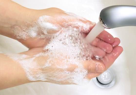 Женщина смывает микробы с рук